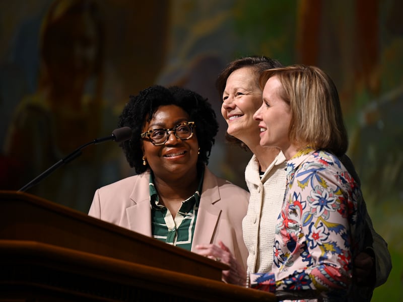 Sister Tracy Y. Browning, President Susan H. Porter and Sister Amy A. Wright smile together as they stand at the podium in the Marriott Center for 2024 Education Week.