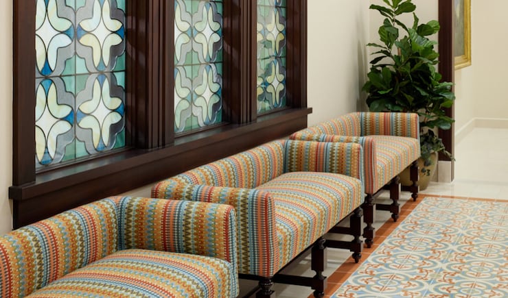 The interior glass patterns were inspired by quatrefoil motifs seen in Spanish colonial architecture. The same pattern is repeated in ordinance room fabrics using the colors blue, gold, opal white and green.