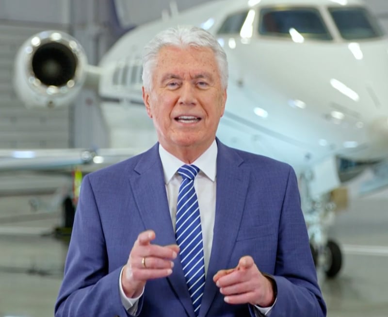 Elder Dieter F. Uchtdorf speaks while standing in front of an airplane in a prerecorded devotional.