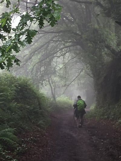 John Rosenberg walking down a trail in Spain during the Camino de Santiago.