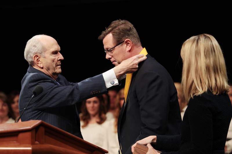 President Russell M. Nelson puts a medallion on school President Clark G. Gilbert after giving him charge at the BYU-Pathway Worldwide inauguration Nov. 16, 2017. President Gilbert’s wife, Christine, stands with him.