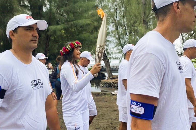 Sixteen-year-old Imihia Teumere carries the Paris Olympic Torch through her community of Mahina, Tahiti, on June 13, 2024.
