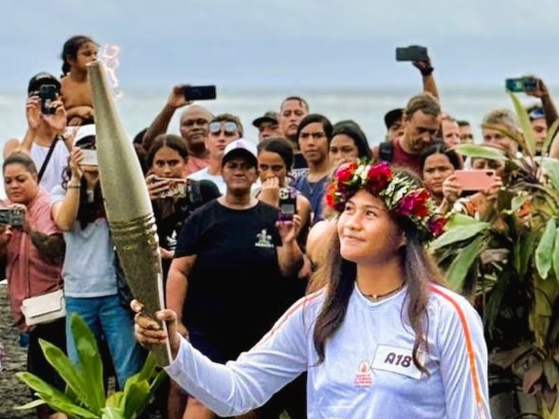 Sixteen-year-old Imihia Teumere carries the Paris Olympic Torch through her community of Mahina, Tahiti, on June 13, 2024.